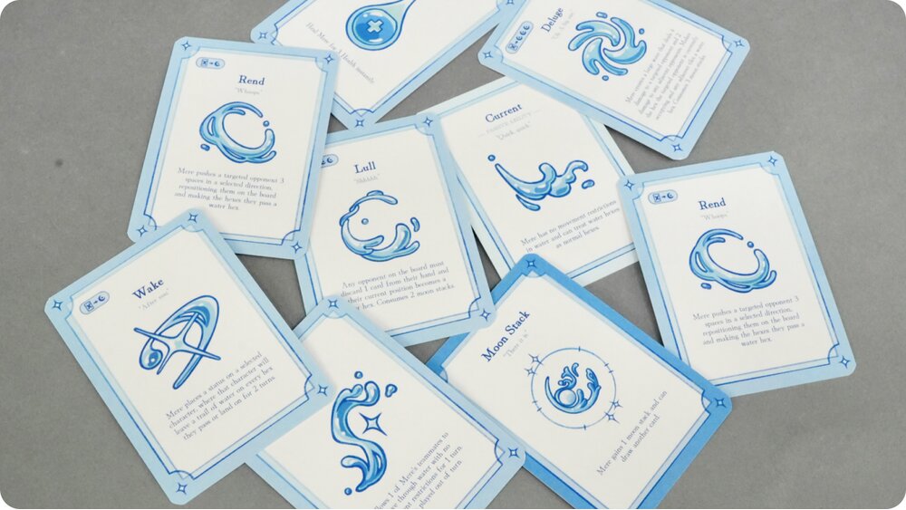 Mere water-themed character card deck spread out with a clay whale piece