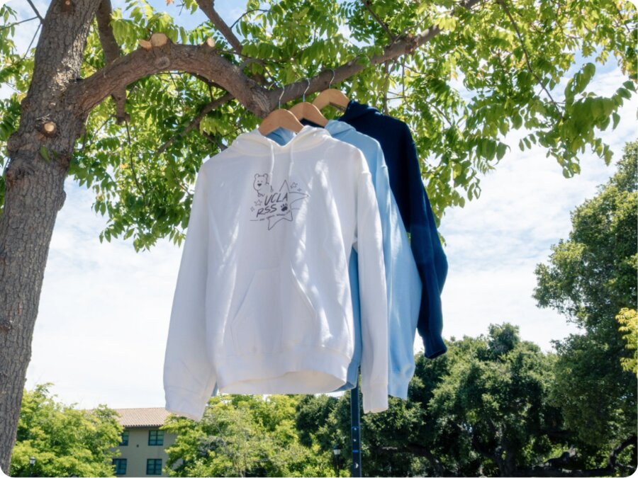 The white and navy hoodies hung side by side from a tree