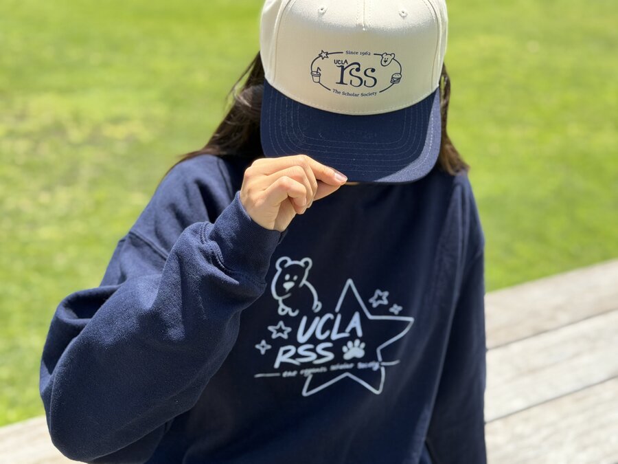 Back of the navy hoodie showing the UCLA RSS star design, cap held to the face