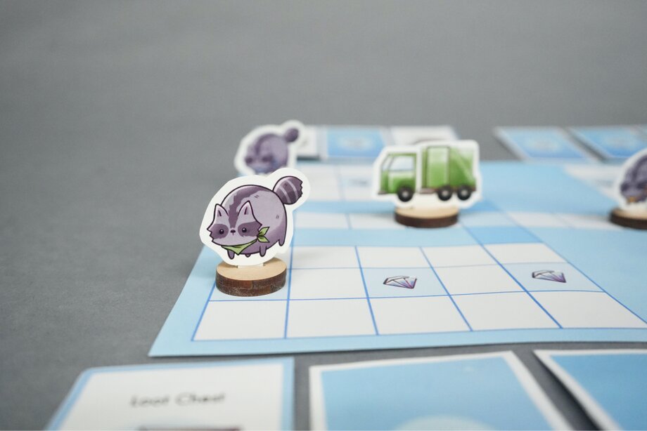 Raccoon and trash truck pieces on the game board